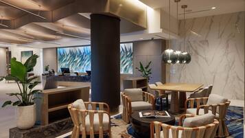 A modern lobby with a reception desk, seating area, and a large pillar.