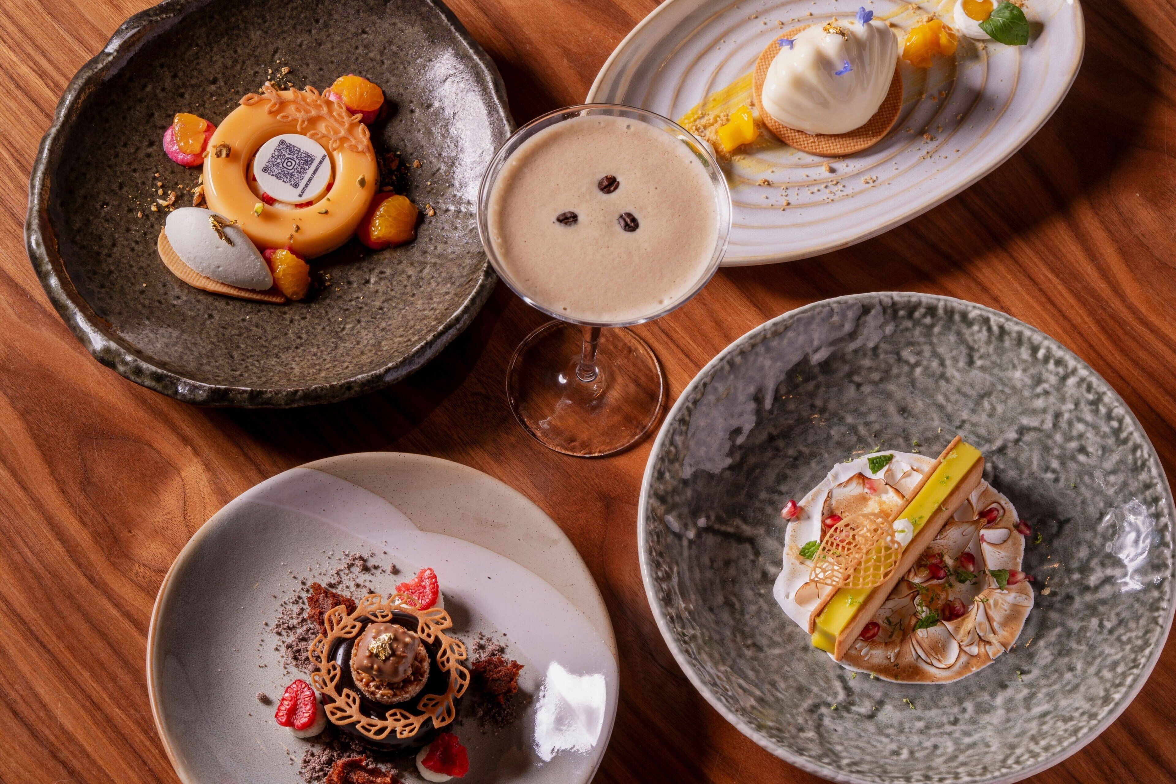 Une variété de desserts présentés sur des assiettes, notamment un dessert au chocolat avec des fraises, un dessert blanc accompagné d’une gaufre et une boisson au chocolat.