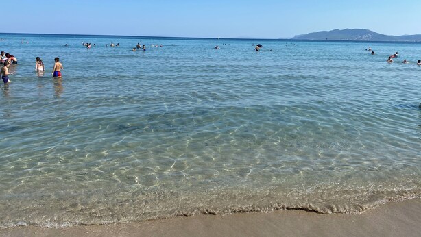 A beach with clear water and people swimming and walking in the shallow areas. - Melinta Stay | Apartment near Athens Airport, Rafina Port & Beach (Artemis)