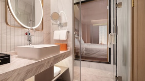 A modern bathroom with a large sink, a mirror, and a glass shower enclosure. - Venus International Hotel  (Changsha)