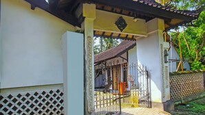 A traditional gate with decorative metalwork and a tiled roof. - OYO 92308 Kos Duduk (Janapria)