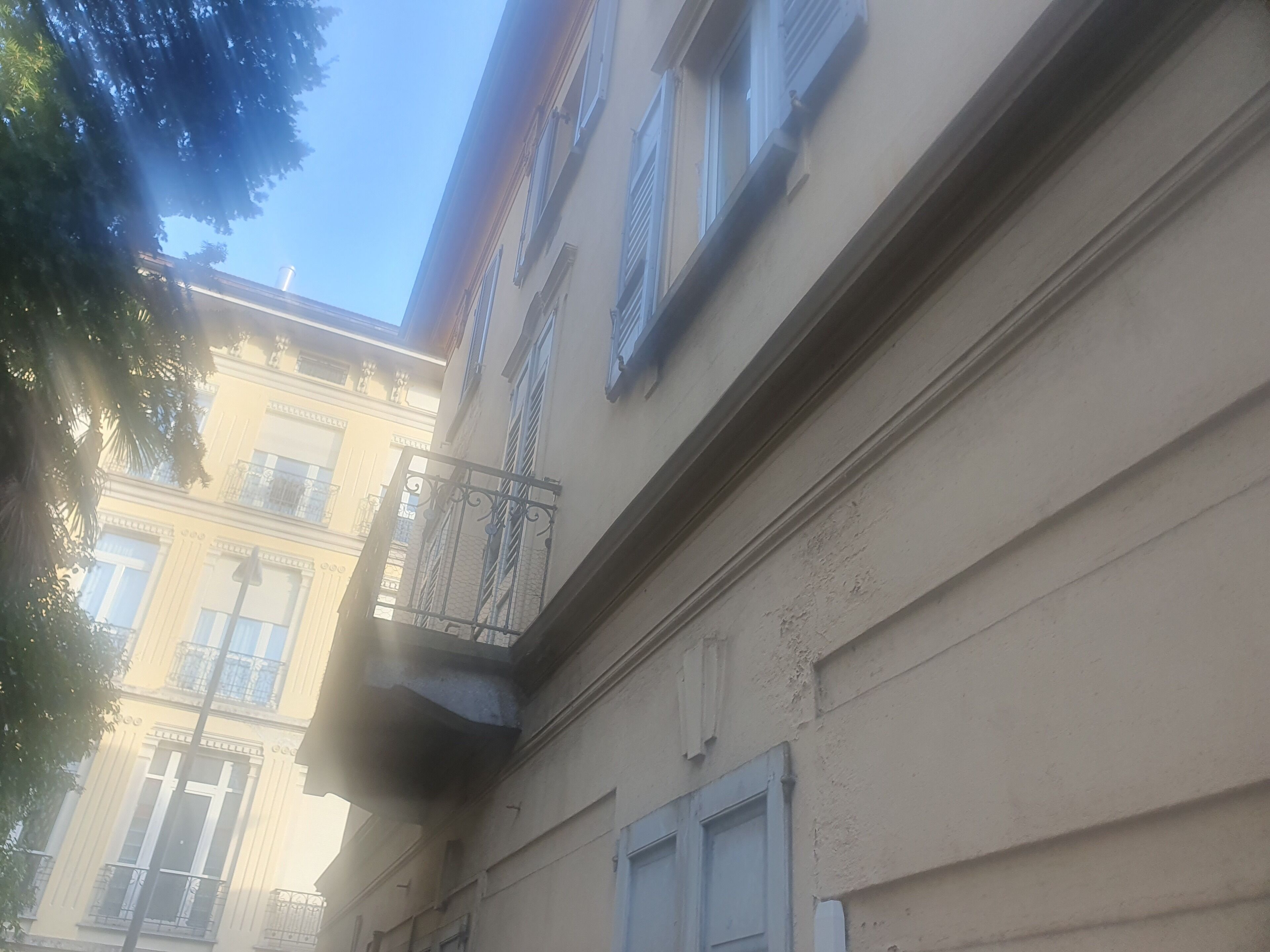 Un coin d’un bâtiment avec un balcon et une fenêtre.