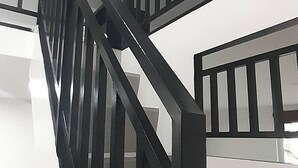 Una escalera con barandillas negras y paredes blancas.