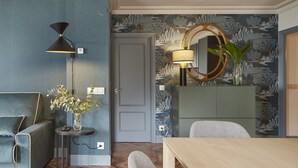 Una habitación con sofá, mesa, lámpara, espejo y armario.