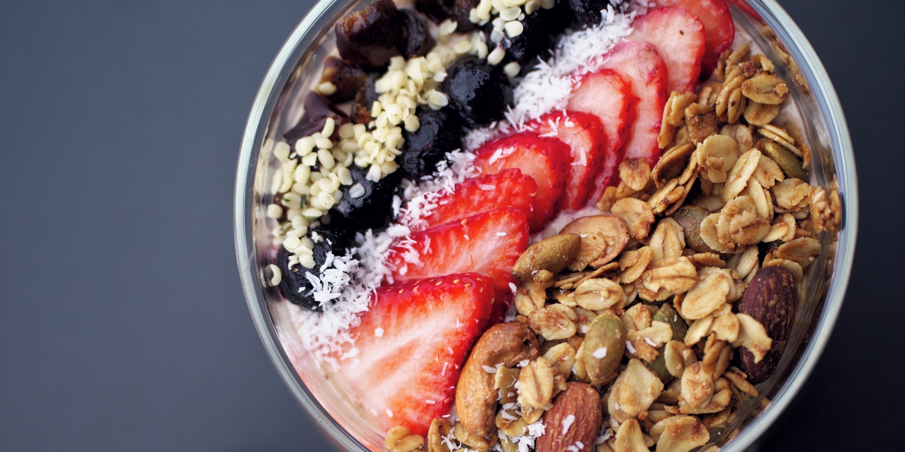 Un tazón de granola con fresas y hojuelas de coco.