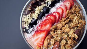 Un tazón de granola con fresas y hojuelas de coco.