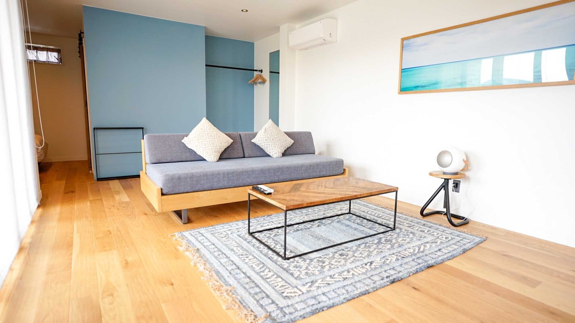 Una sala de estar moderna con un sofá, una mesa de centro y un cuadro en la pared.