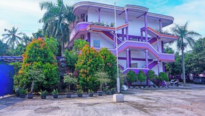 Un edificio de varios pisos con balcones y plantas en macetas.