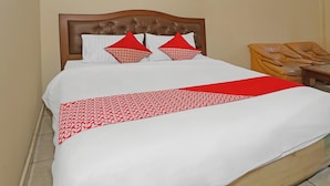 Una cama bien hecha con una colcha estampada y dos almohadas.