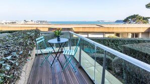 A balcony with a table and chairs, overlooking a coastal view. - Le Parc de La Ronceray by Interhome (Dinard)