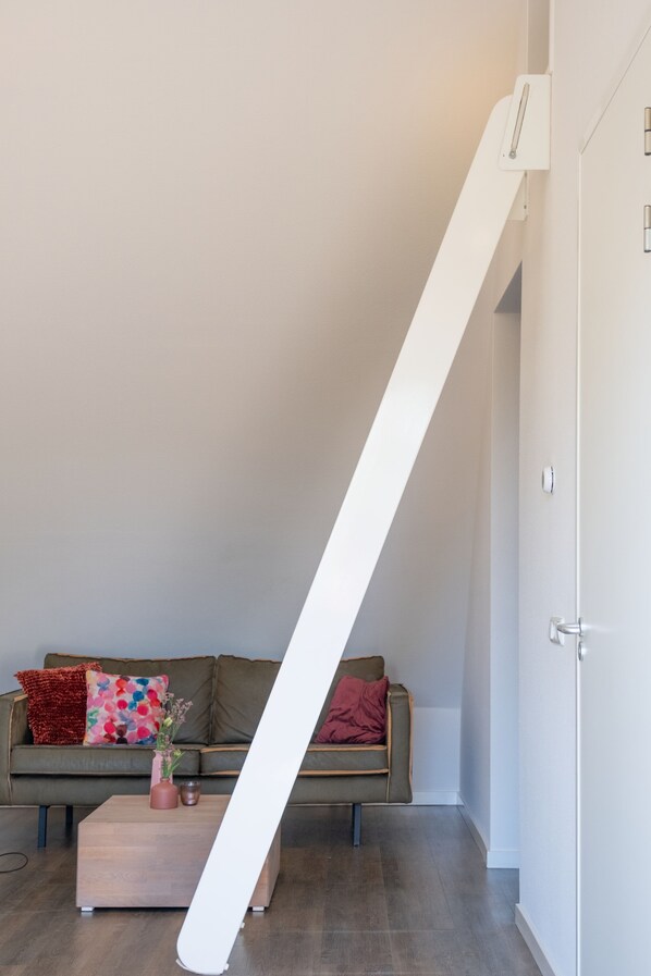 A modern living room with a sofa, a coffee table, and a staircase.