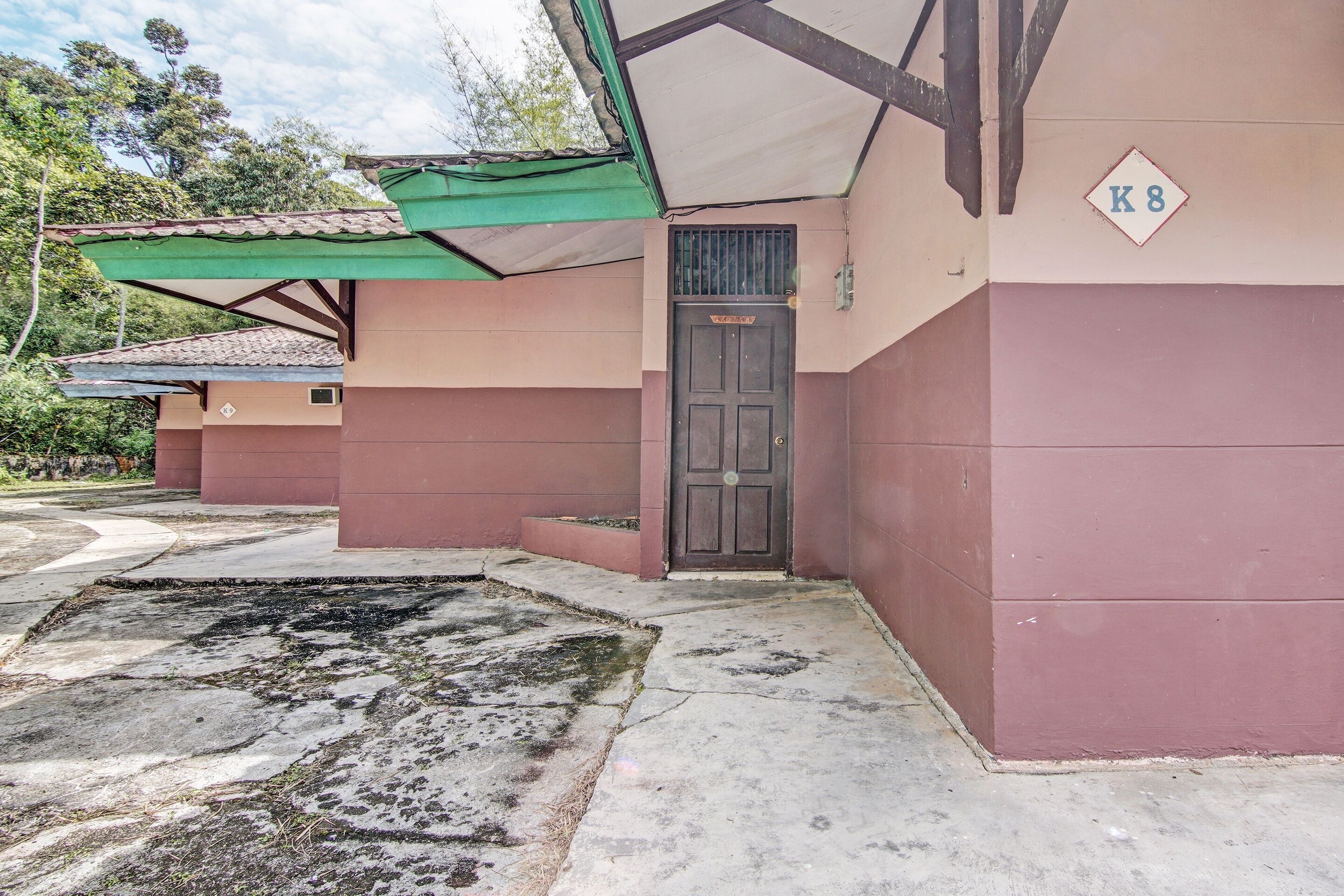 Un edificio con toldo verde, una puerta con la etiqueta 
