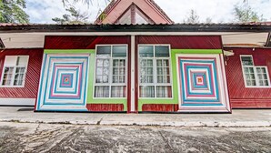 Un bâtiment doté de deux grandes portes et de grandes fenêtres, et dont la façade est de couleur rouge et verte.