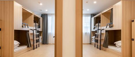 A mirrored room with bunk beds, wooden walls, and a light-colored floor.