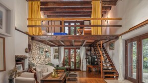 A spacious living area with a stone wall, wooden staircase, and a cozy seating arrangement. - Lovely Holiday Home By The Sea (Crikvenica)