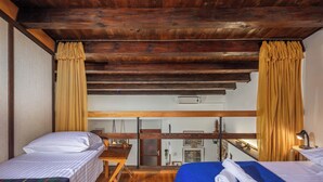 A room with two beds, wooden floors, a wooden ceiling, and a window with curtains. - Lovely Holiday Home By The Sea (Crikvenica)