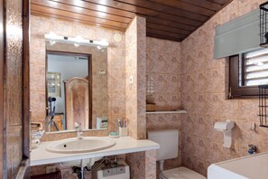 A bathroom with a sink, mirror, toilet, and a window. - Lovely Holiday Home By The Sea (Crikvenica)