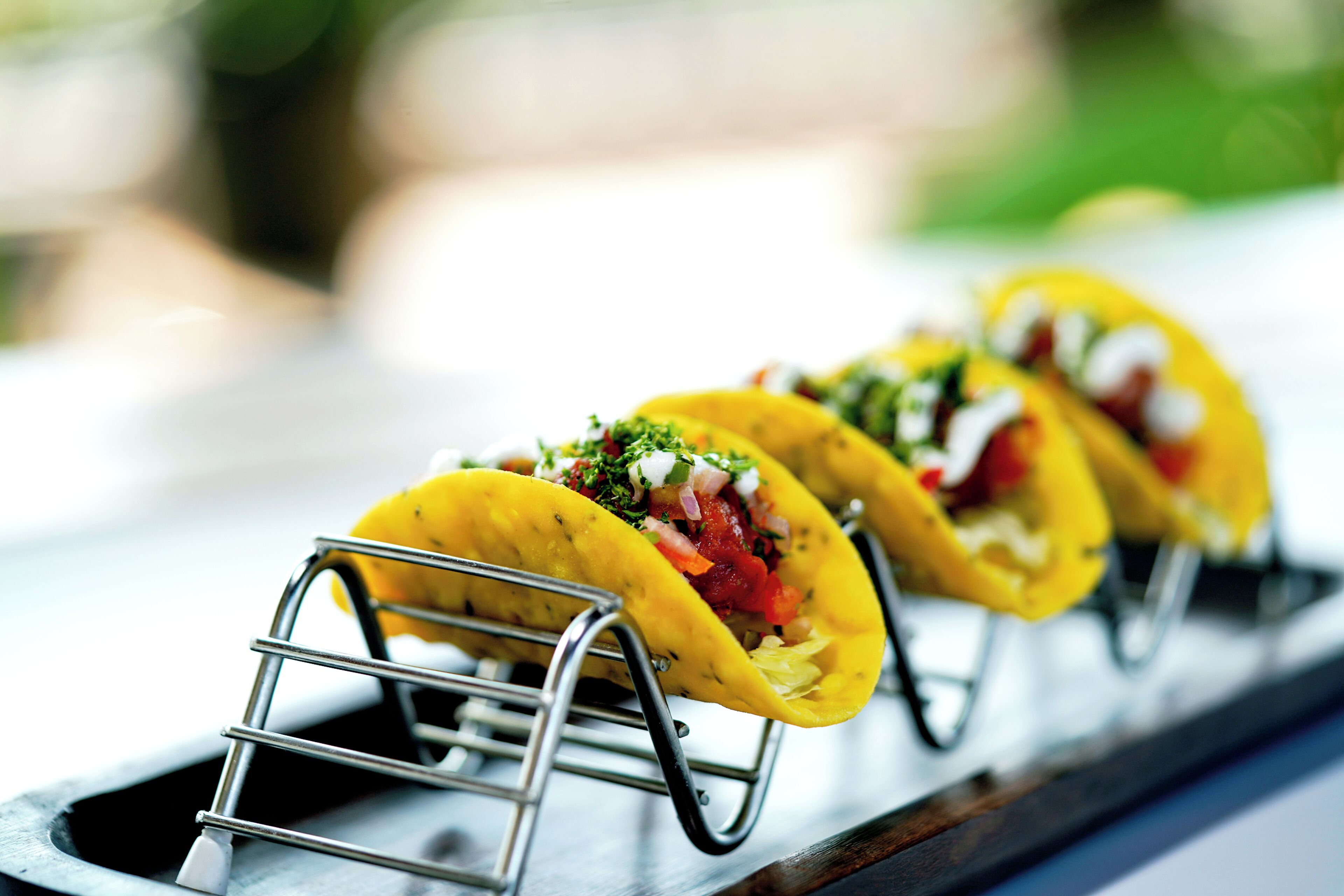 Drie taco's op een metalen rek.