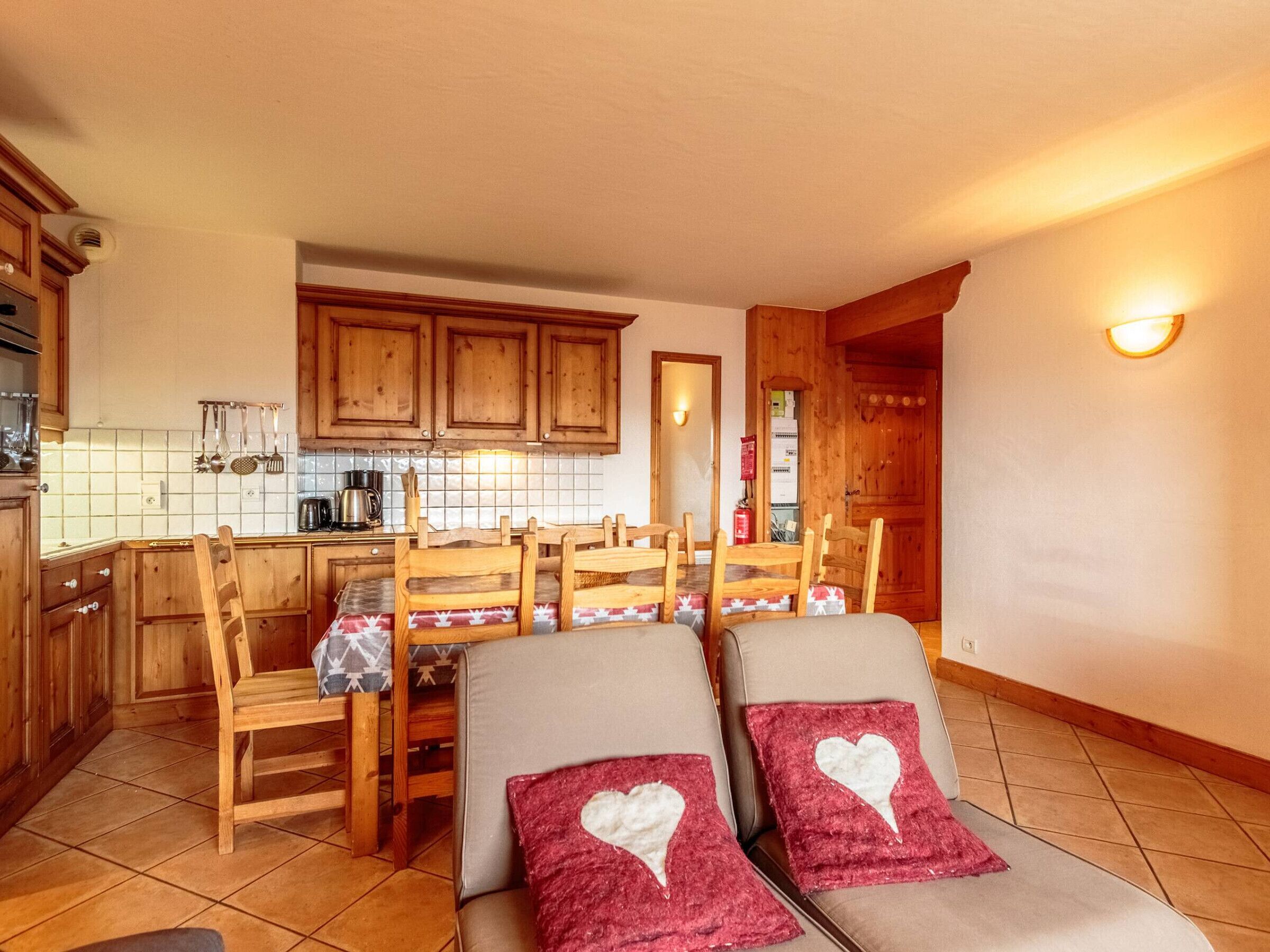 Una cocina acogedora con armarios de madera, salpicadero de azulejos y un comedor con mesa y sillas.