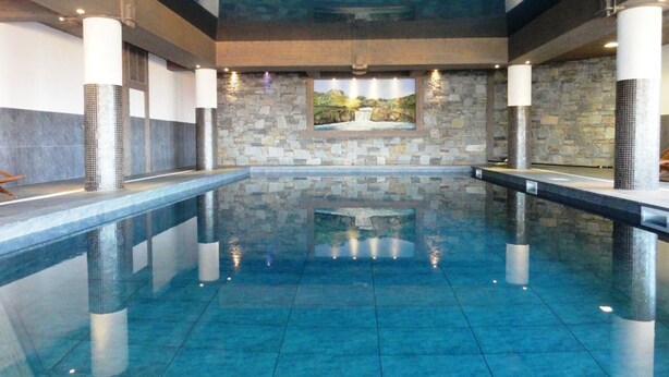 A large indoor swimming pool with stone walls and a mural. - Ski-in/ski-out apartment, 4 bedrooms, 8 ppl, covered parking, WiFi (Les Arcs 1800)