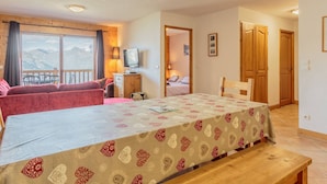 Una habitación acogedora con una mesa de comedor, un sofá y un televisor.