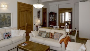 A living room with two white sofas, a wooden coffee table, a wooden cabinet, and a painting on the wall. - Villa Ayghedzor (Yerevan)