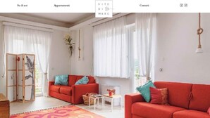 Ein modernes Wohnzimmer mit einem roten Sofa, einem gemusterten Teppich und einer Holzkommode.