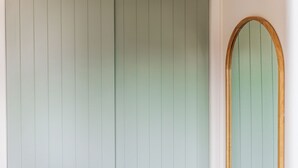 Una habitación con un gran ventanal corredera y una ventana con marco de madera.