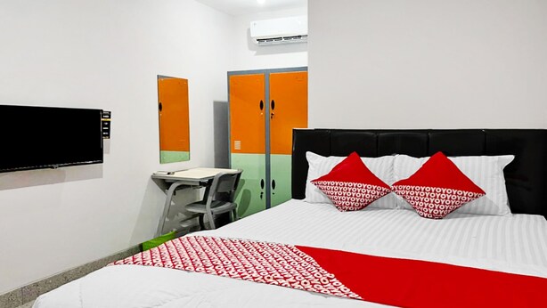 A hotel room with a bed, a desk, and a chair.