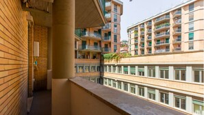 A multi-story residential building with balconies, brick walls, and a clear view of neighboring structures. - La Dolce Vita - Stylish Flat inTrastevere 60sqm (Roma)