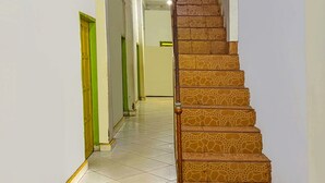 A staircase with a unique giraffe-patterned design, leading to a room with a green door and white walls. - Hotel O Melati Bm Pangkep (Samalewa)