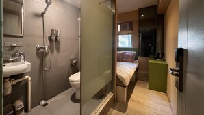 A modern bathroom with a shower, toilet, and sink. - POP E INN (Kowloon)