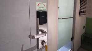 A door with a card reader, a keyhole, and a metal handle. - POP E INN (Kowloon)