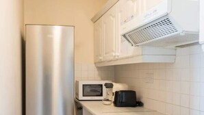 A compact kitchen with a stainless steel refrigerator, a microwave, a toaster, an oven, and a dishwasher. - Central 2BD Flat in Heart of Dublin (Dublin)