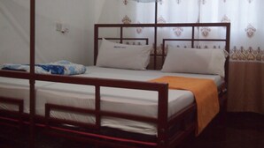 Una cama individual con estructura de madera, ropa de cama blanca y un dosel azul.