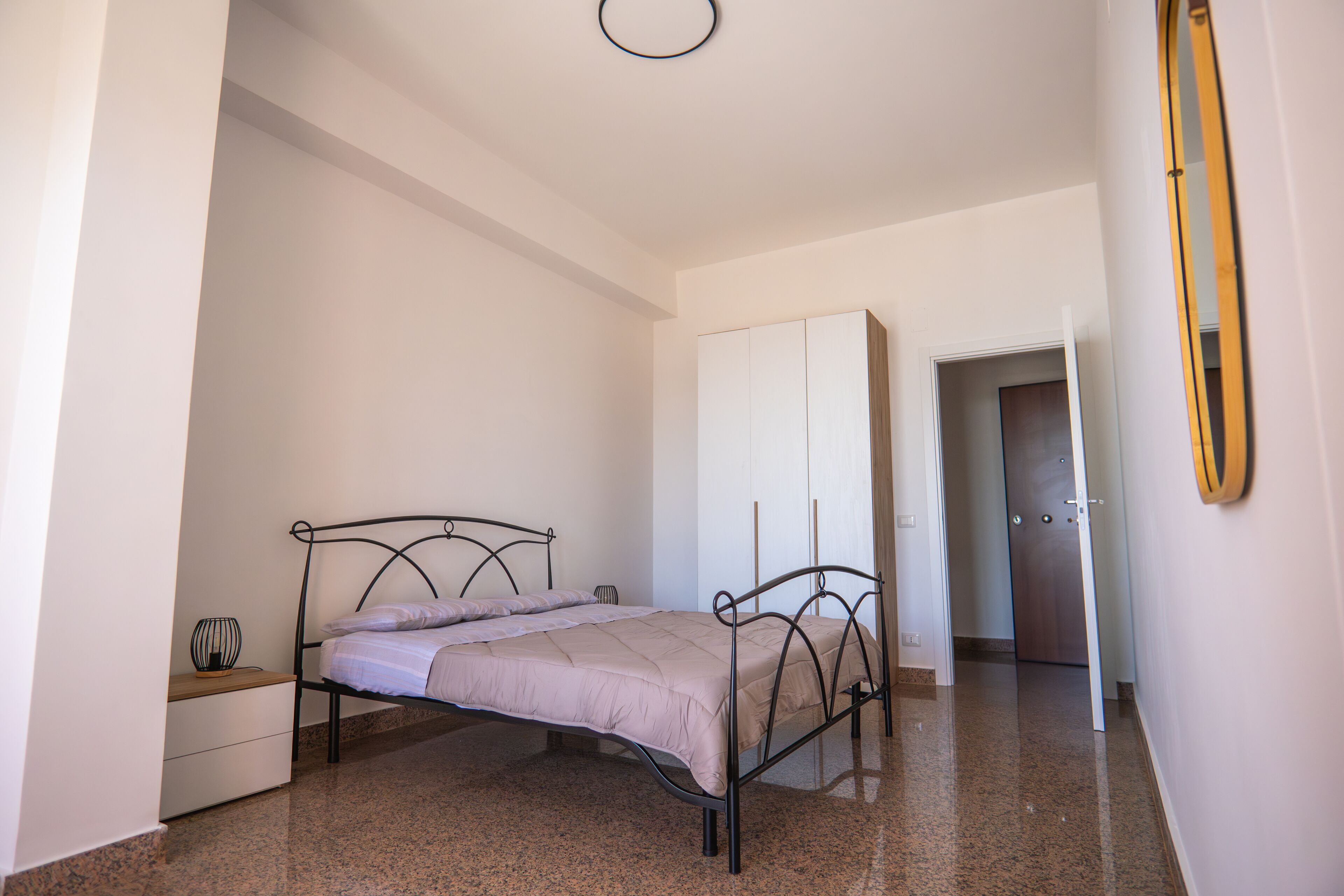 Une chambre à coucher avec un lit, une armoire et un miroir.
