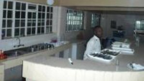A kitchen with a counter, sink, and window. - Maralink Hotel (Narok)