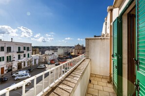 A balcony with a view of a street and buildings, including a church.