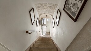 A staircase with stone walls and a framed picture on the right. - 3189 Dimora Bellargo by Barbarhouse (Martina Franca)