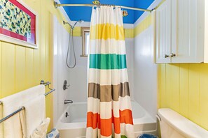 A bathroom with a bathtub, a shower curtain, and a toilet. - Beachfront, Private home, dog friendly, heated pool, 4 BR (St. George Island)