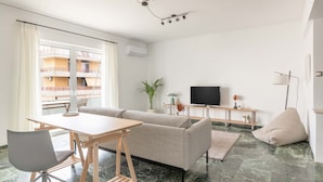 Un soggiorno moderno con un divano, un tavolo da pranzo e una televisione.