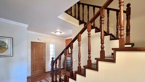 A wooden staircase with a handrail, leading to a landing.