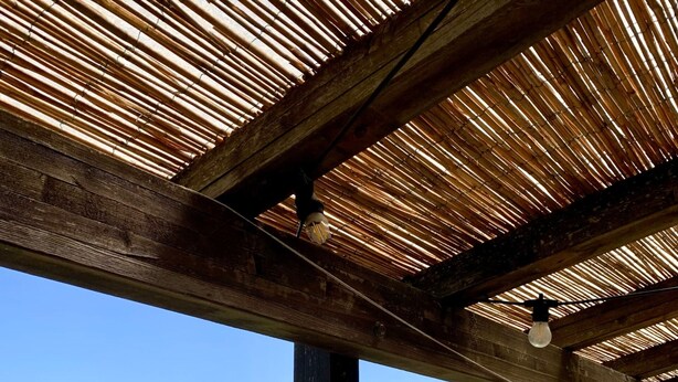 A wooden pergola structure with a view of a green landscape. - The Olive  4+2 (Montescudaio)