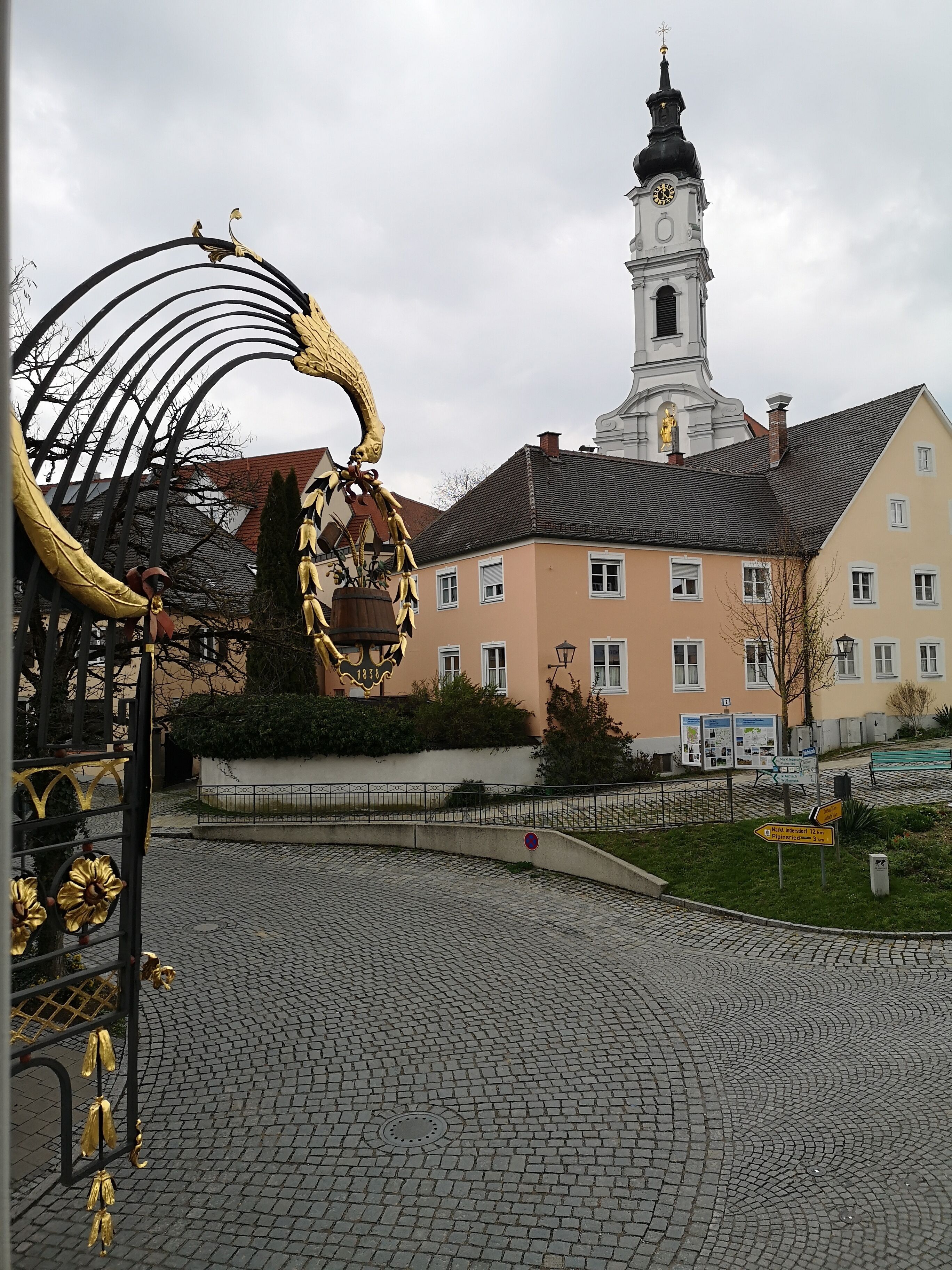 A cobblestone plaza with a historic building featuring a clock tower.