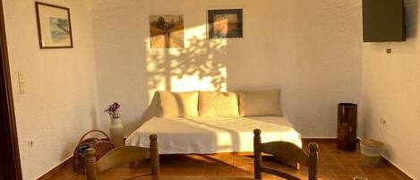 Una habitación acogedora con una cama, una mesa con un cuenco y una silla.