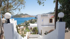 A view of Golden Sun Hotel with a clear blue sea and hills in the background.