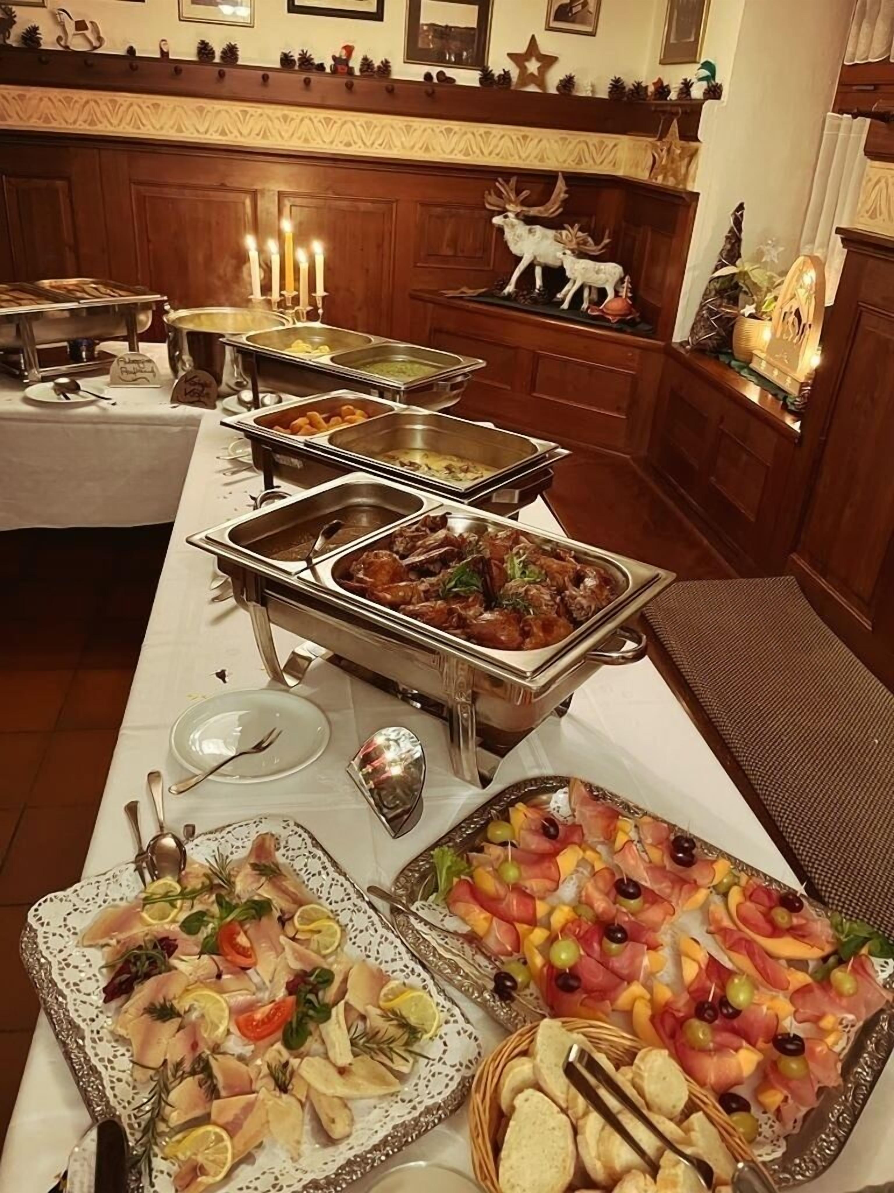 A buffet setup with various food items and a decorative deer statue.