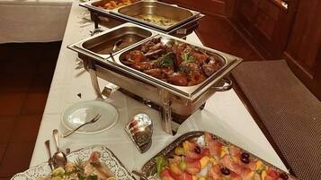 A buffet setup with various food items and a decorative deer statue.