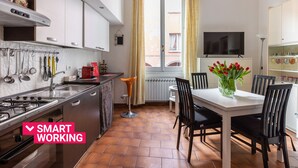 Uma cozinha moderna com área de refeições, apresentando fogão, pia e mesa de jantar com cadeiras.