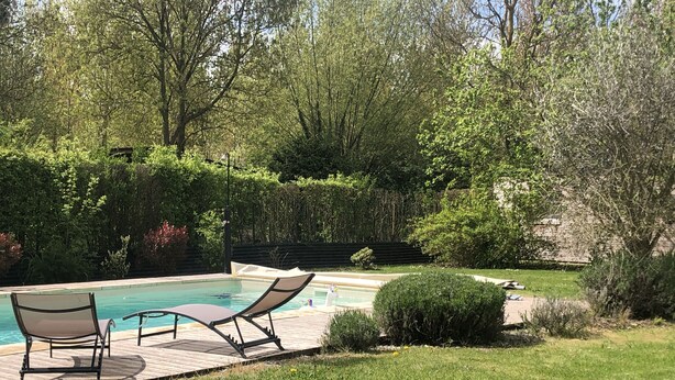 A backyard with a swimming pool, two lounge chairs, and a well-maintained lawn. - Modern country house with spacious rooms and swimming pool (Doingt)